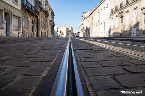 Rail de tramway au ras des pavés dans une rue de Bordeaux