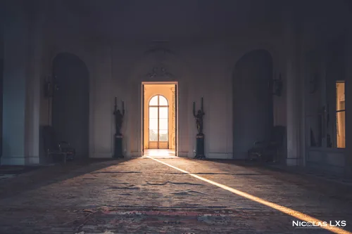 Rai de lumière traversant un grand salon par une porte-fenêtre, Domaine du Réveillon