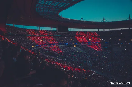 Concert de Coldplay : gradins d'un stade illuminés de rouge